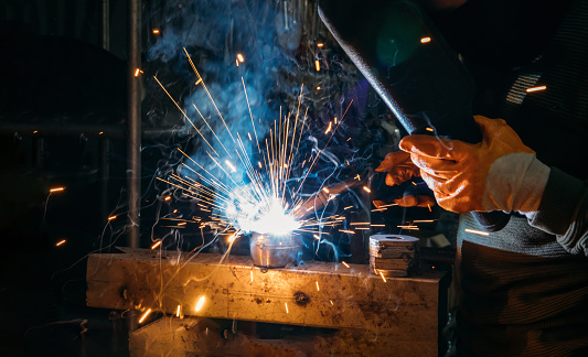Soldador industrial trabajador soldando acero o hierro en una fábrica. photo
