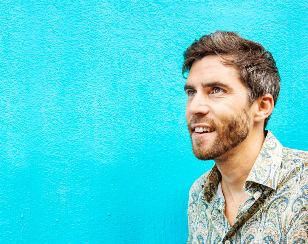 istock Smiling young man standing against a blue wall outside 1397506719