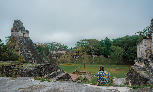 Young Caucasian man  sitting and looking at   Tikal National Park