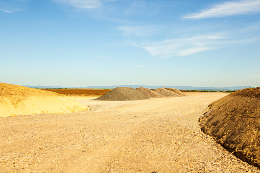 entrance construction site, driveway of building site. Pile of sand and Gravel for construction. limestone materials for construction industry.