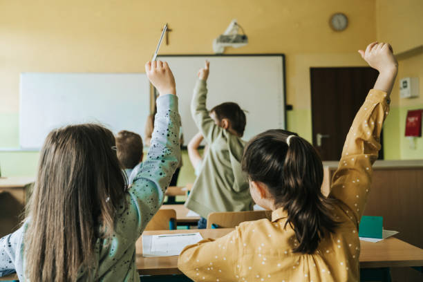 istock school children in classroom putting up hands 1397508769