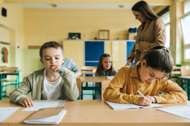 istock elementary school children learning concentrated at desk in classroom 1397509410