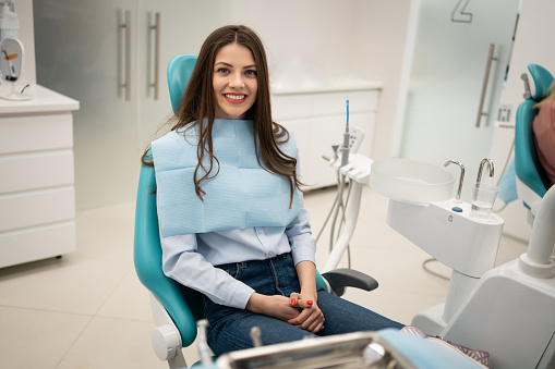Portrait of young Caucasian female patient sitting on the dentist's chair at the dental clinic
