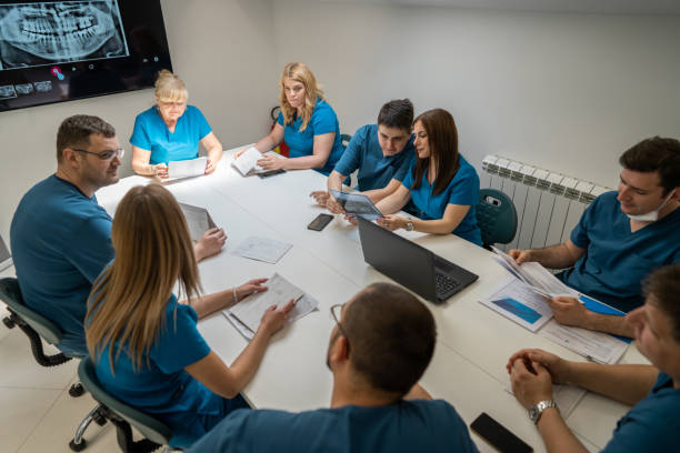 Group of female and male dentist having a meeting at the office, ad the dental clinic stock photo