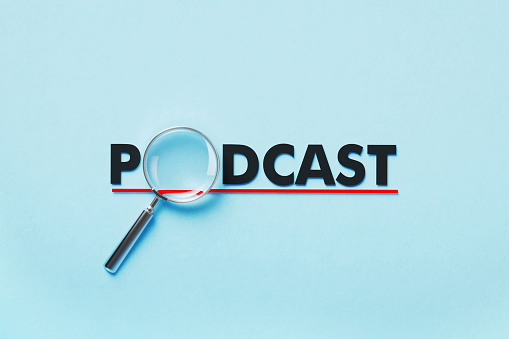 Magnifier forming podcast word on blue background. Horizontal composition with copy space. Analysis concept.