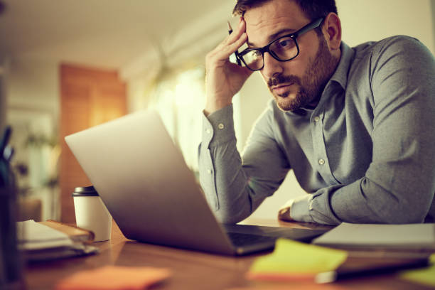 istock Worried businessman working on a computer at home office. 1397511715