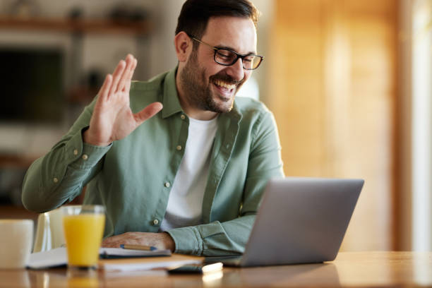 istock Happy man waving while having a video call at home office. 1397511824
