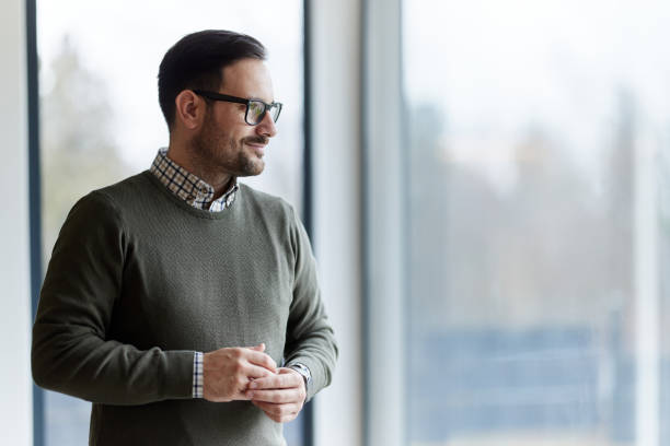 istock Young smiling man day dreaming by the window. 1397514560