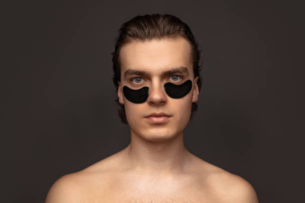 istock Young adorable man with well-kept skin using patches under eyes isolated over grey background. Fashion, cosmetics, health care, skin care, beauty 1397515375