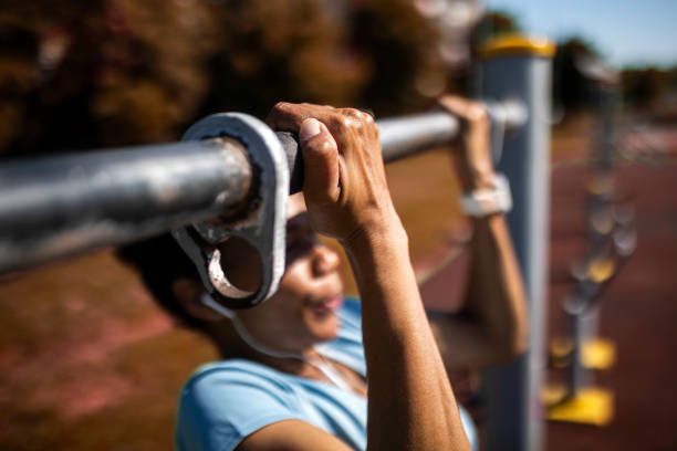 wysportowana kobieta robiąca podbródki na siłowni na świeżym powietrzu - chin ups audio zdjęcia i obrazy z banku zdjęć