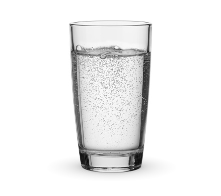 Glass of drinking carbonated sparkling water isolated on white background