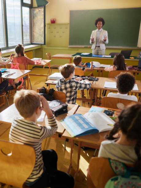 istock Back view of elementary students having a class in the classroom. 1397515673