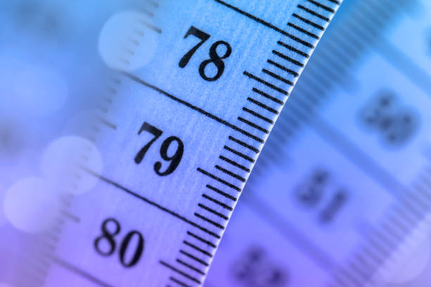 Close-up of a tape measure on a defocused lights bokeh background. Shallow depth of field.