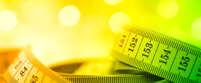 Close-up of a rolled up tape measure. Shallow depth of field, beautiful bokeh. Space for copy.