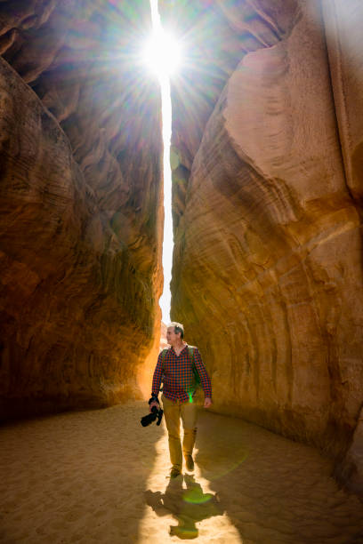 istock Smiling man with camera walking through natural wonder 1397522876