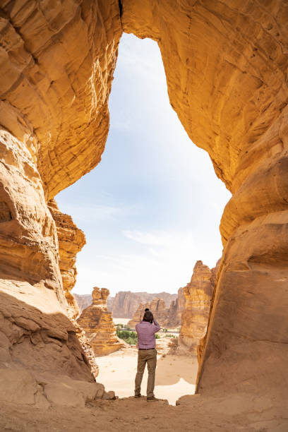 Man photographing sandstone outcrops from Jar Rock, Al-Ula