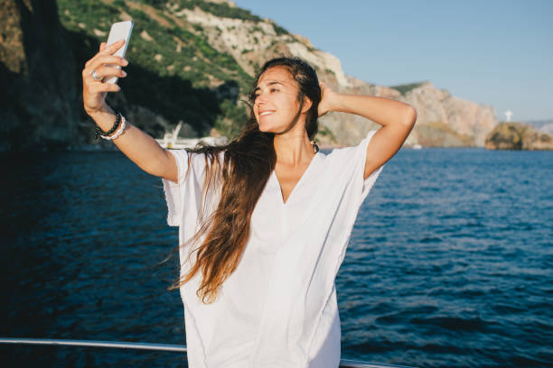 istock Woman taking selfie on smart phone on yacht. 1397525310