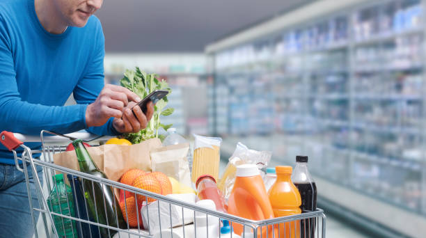 istock Man doing grocery shopping and using his smartphone 1397526854