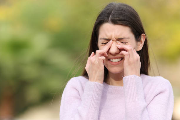 Teen scratching itchy eyes complaining outdoors stock photo