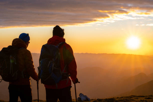 istock Hikers watching romantic sunset in mountains 1397527146