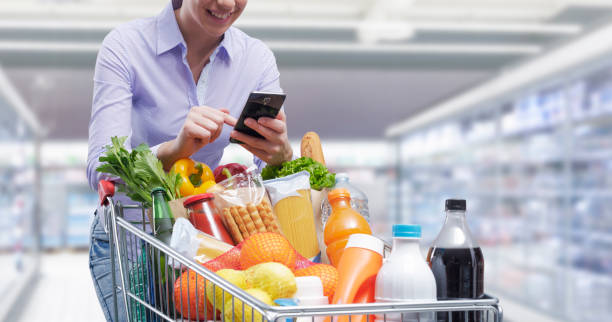 istock Happy woman doing grocery shopping and using her smartphone 1397527425