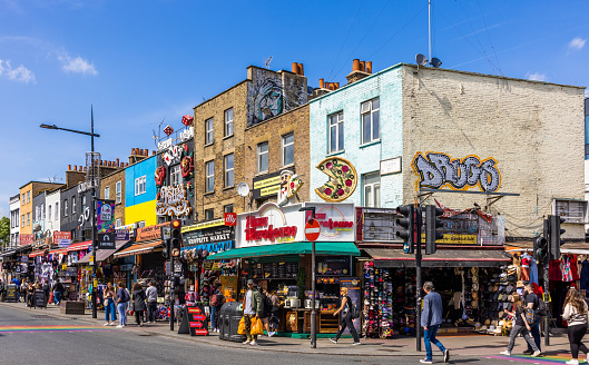 Camden Town in London is well known for its market, street foods, Pubs and Cafes.  The area is popular with tourists, teenagers and punks. The thriving nightlife scene includes live music in alternative clubs and old-school pubs, and major stars playing at the Jazz Cafe and the Roundhouse.  Shot 13 May 2022.