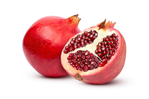 Fresh ripe pomegranate with cut in half sliced isolated on white background.