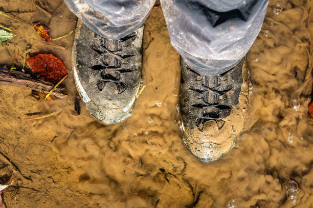 하이킹 부츠는 진흙에 갇혀 있습니다. 흙으로 덮인 여행 신발 - mud shoe boot wet 뉴스 사진 이미지