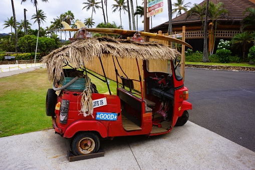 August 30, 2019 in Honolulu, Hawaii, USA: red Hawaiian tricycle with surfboard.