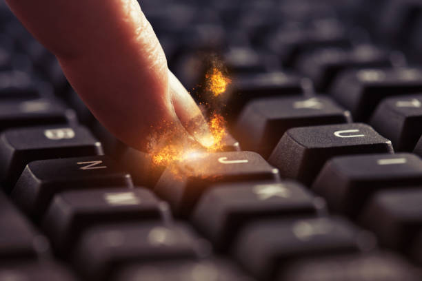 Spark of creativity: woman's fingertip on computer keyboard ignites in flame stock photo