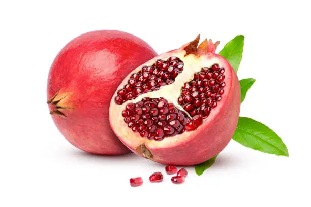 Closeup pomegranate fruit with cut in half sliced and green leaf isolated on white background.