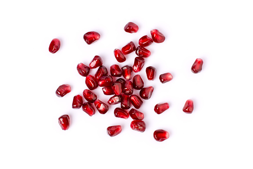 Pile of fresh pomegranate seeds isolated on white background. Top view. Flat lay.