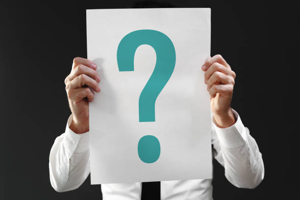 istock Perplexed businessman holding paper with question mark printed 1397537424