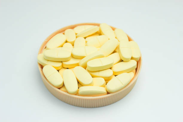 stos tabletek suplementu wapnia i witaminy d izolowanych na białym tle - vitamin pill capsule pill echinacea zdjęcia i obrazy z banku zdjęć