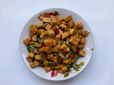 stir fry tofu and green beans on a plate on a white background. healthy food background concept, food recipe, homemade, handmade, vegetable, vegetarian, diet, breakfast,dish,cuisine, meal,lunch,dinner
