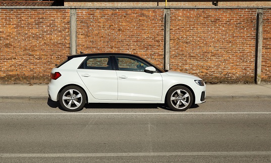 Udine, Italy. May 15, 2022. Side view of the new  white and black Audi A1. Brick wall on background.