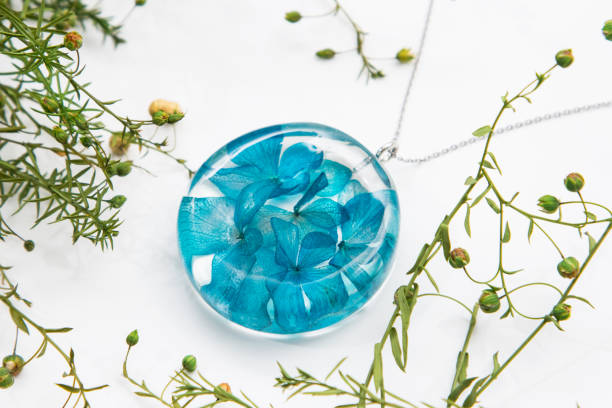Real flowers in epoxy resin, jewelry stock photo