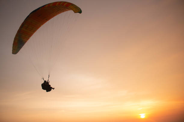 istock Tandem paragliding closeup over the ocean while golden sunset 1397544280