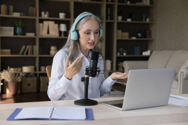 istock Elder grey haired teacher woman using laptop, wireless headphones 1397545151