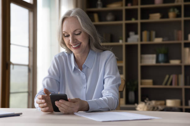 istock Happy retired grey haired lady using online app on smartphone 1397545213