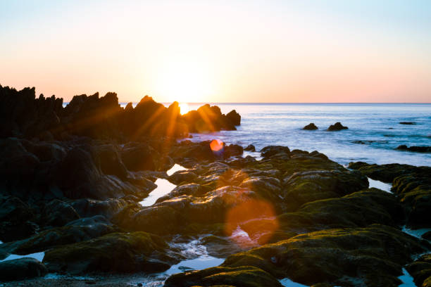 istock Sunset over the ocean water at low angle beach view 1397545762