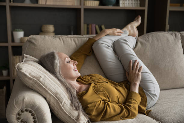 istock Relaxed happy mature grey haired lady resting on comfortable sofa 1397545788
