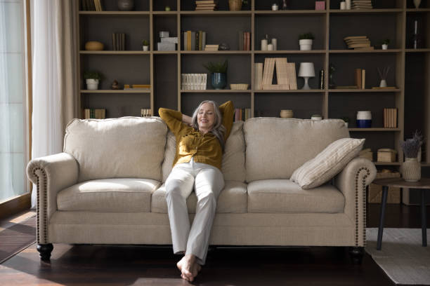 istock Relaxed cheerful middle aged woman sitting on comfortable sofa 1397545807