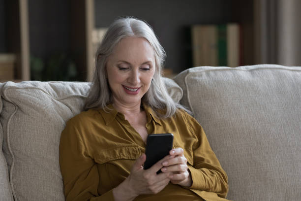 istock Happy focused senior cellphone user woman reading text message 1397545840