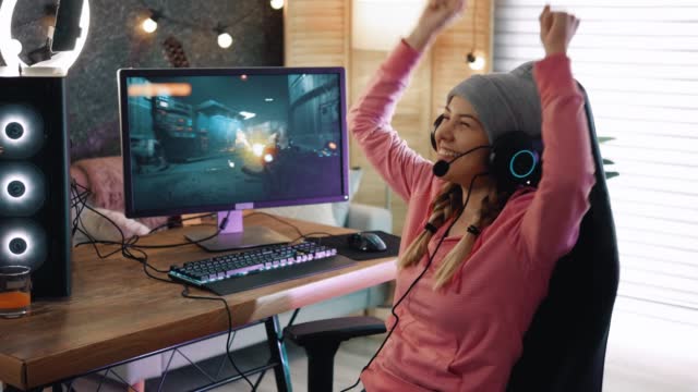 Professional female game streamer raising its hands and rejoices in success and victory