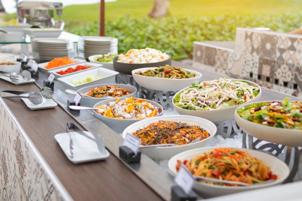 Assorted fresh salads displayed on a buffet in individual containers at garden restaurant.