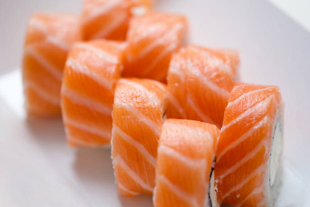 Delicious philadelphia masago rolls on white plate. Sushi rolls with salmon cucumber and cheese and japanese food concept
