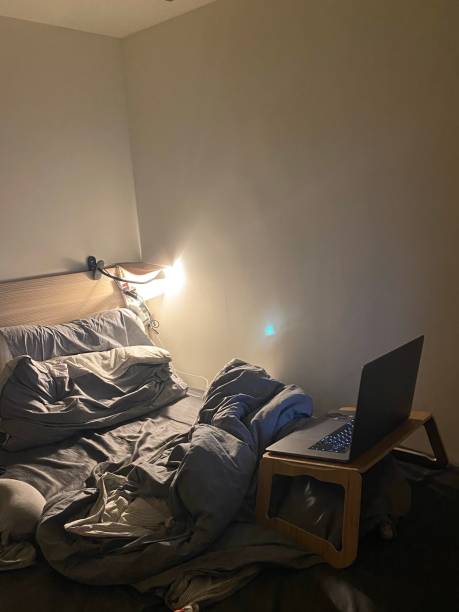istock Cozy Bed with Laptop and Reading Light 1397548029