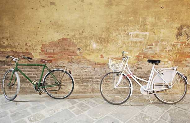 Dois bicicletas contra uma parede de tijolo - fotografia de stock