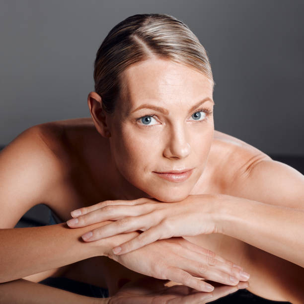 Beautiful mature woman posing in studio against a grey background